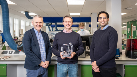 Three people - the Figura team with the Best Pitch Award, standing in a laboratory setting